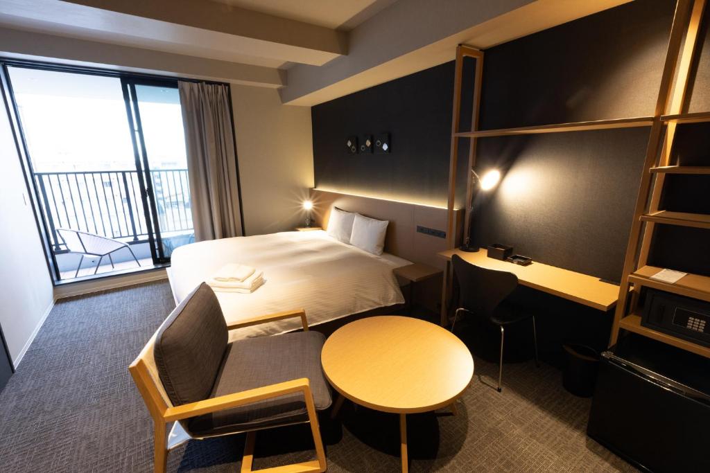 东京N+ Hotel 秋叶原的配有一张床、一张桌子和一张桌子的酒店客房