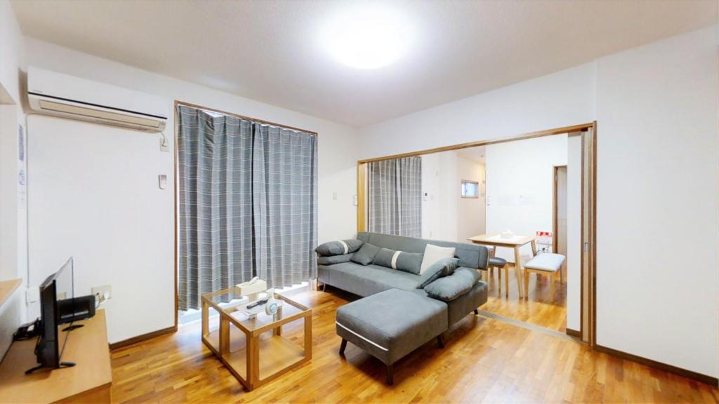 那霸Suminchu House Ichariba的带沙发和电视的客厅