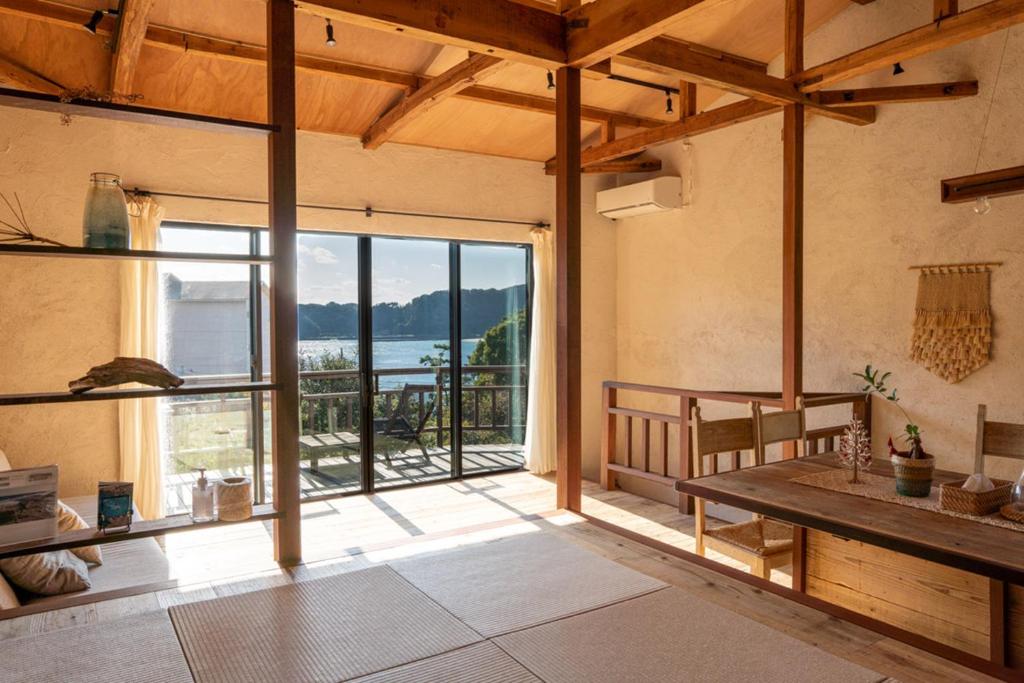 南伊豆町尤米加玛别墅度假屋的客厅设有大窗户和桌子