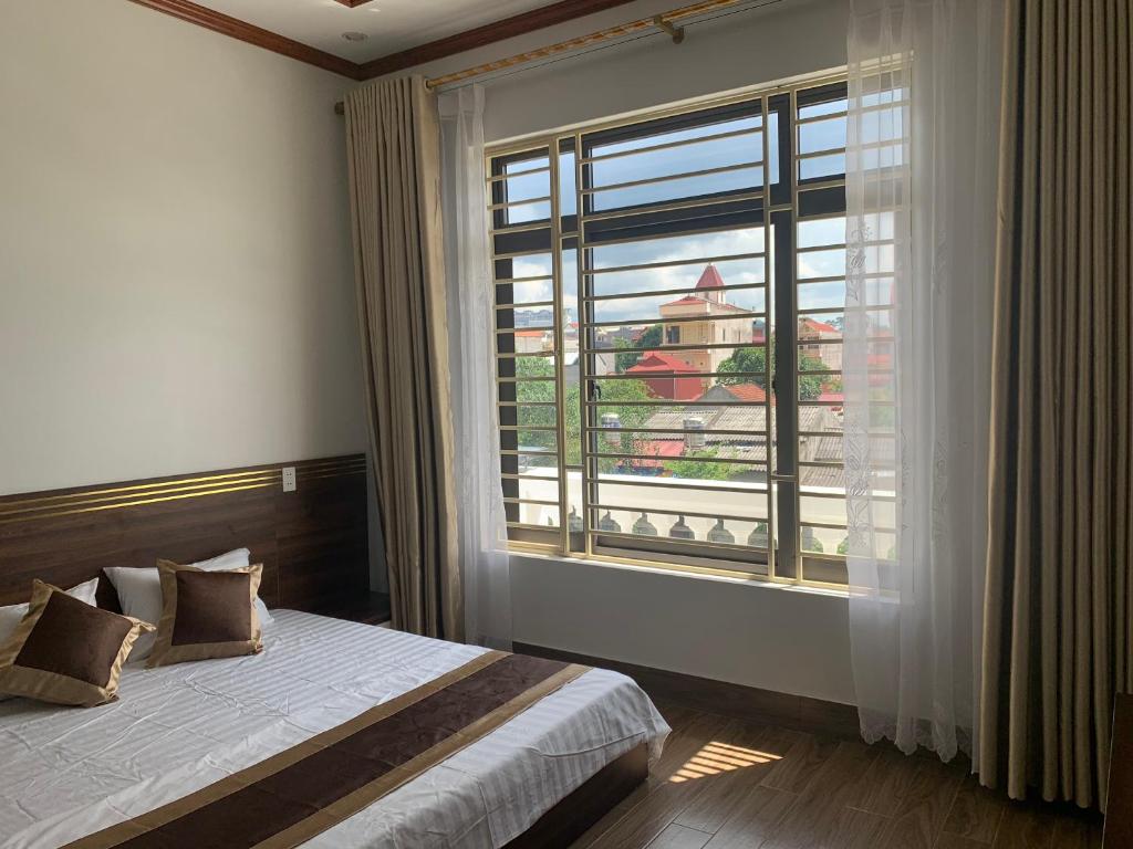 谅山Khách sạn Ánh Trăng的一间卧室设有一张床和一个大窗户