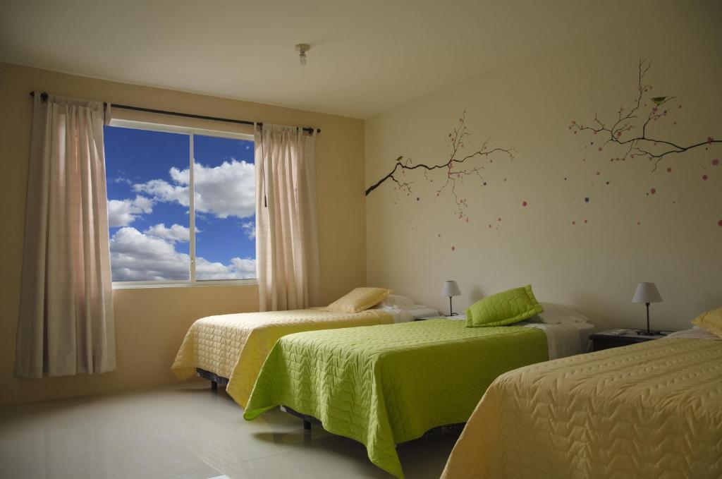 阿约拉港加拉帕戈斯海洋之梦旅舍的一间卧室设有两张床和窗户。