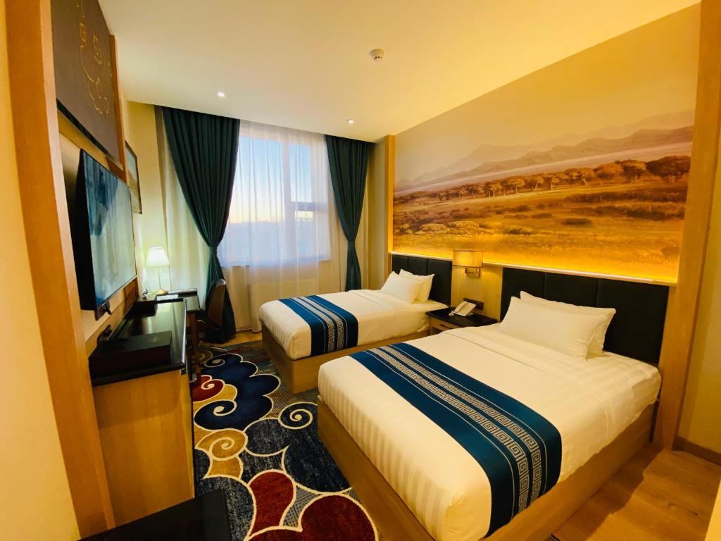 Mazaalai Hotel的酒店客房设有两张床和一台平面电视。