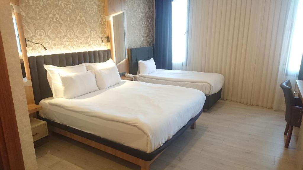 安塔利亚Isnova Hotel Airport的酒店客房,配有两张床和椅子