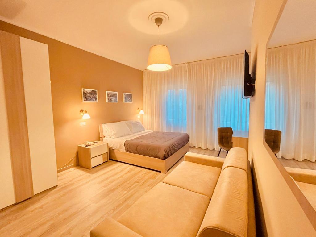 菲乌吉Albergo Ristorante Belsito的一间卧室配有一张床和一个沙发
