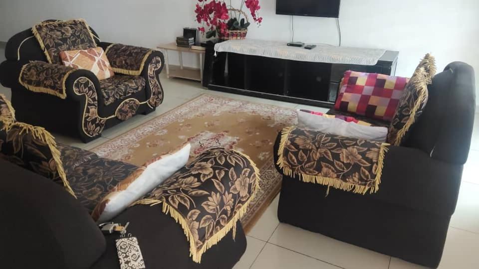 日落洞Penang holiday villa的客厅配有两把椅子和一张沙发