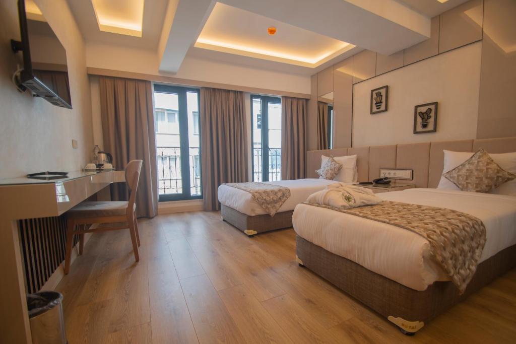 伊斯坦布尔Vera Life Hotel的酒店客房配有两张床和一张书桌