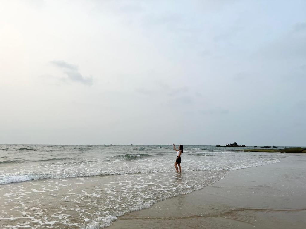 隆海Oceanami Villa Long Hải - Vũng Tàu的站在海滩上水面上的女人