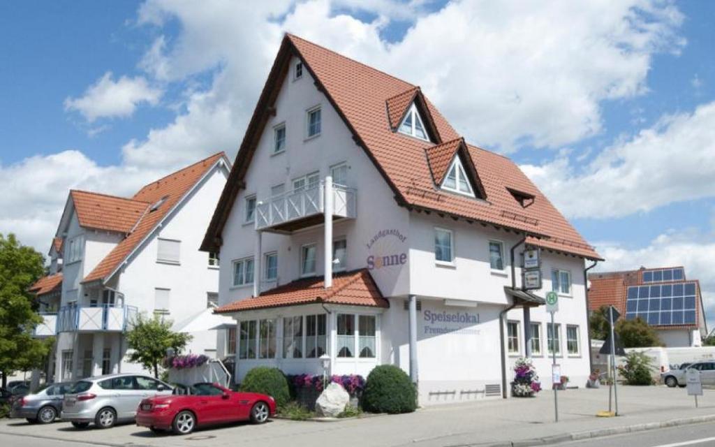 UnlingenLandgasthof Sonne的一座白色的大建筑,有红色的屋顶