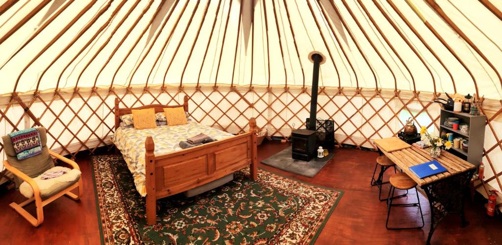 GraffhamBeautiful Yurt with stunning South Downs views的蒙古包内一间卧室,配有一张床和一张桌子