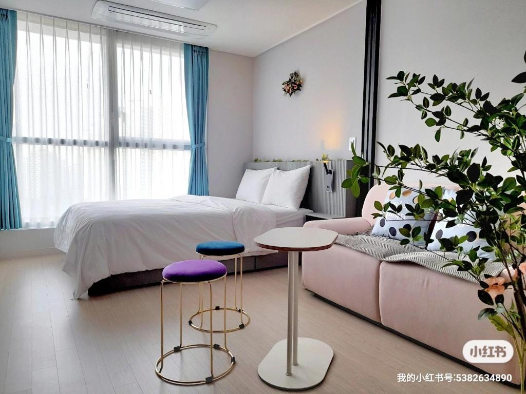 仁川市Well stay的一间卧室配有一张床、一张沙发和两张凳子。