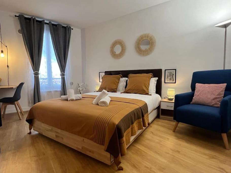 莱克朗兰比塞特尔T2 Paris 5 ' Tour Eiffel 15' Parking的一间卧室配有一张大床和一张蓝色椅子