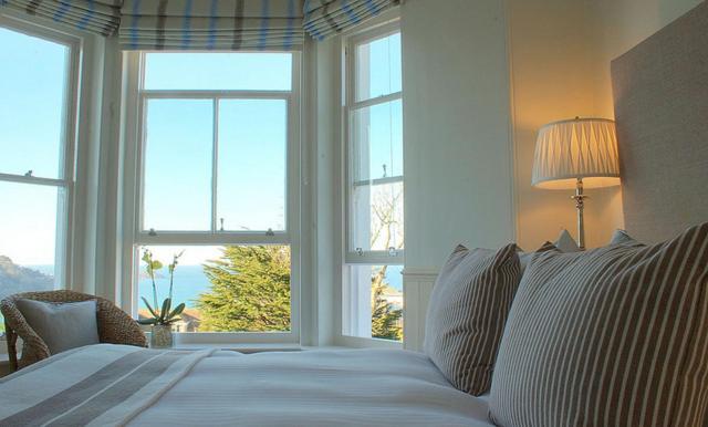 圣艾夫斯Headland House Luxury B&B的卧室设有一张带窗户的白色大床
