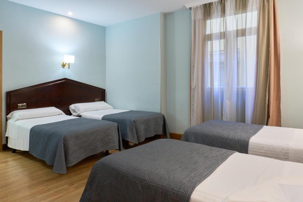 格拉纳达Porcel Navas的酒店客房设有两张床和窗户。
