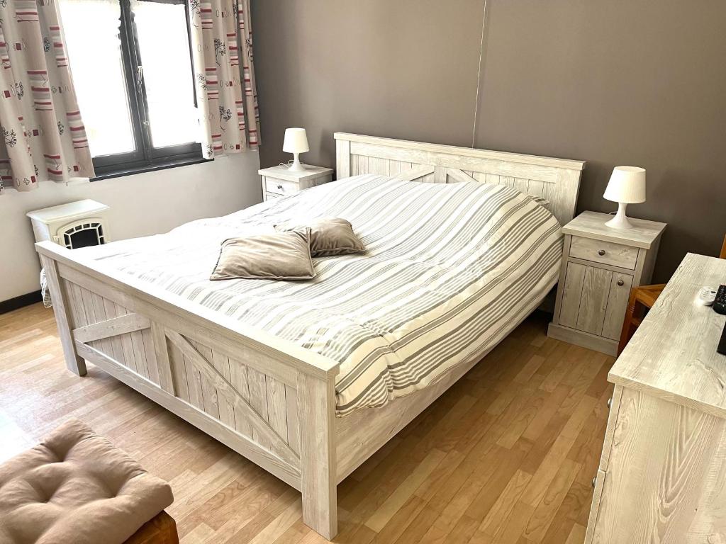 布兰肯贝赫Chez’ Elle的卧室配有一张带两张桌子的大型白色床