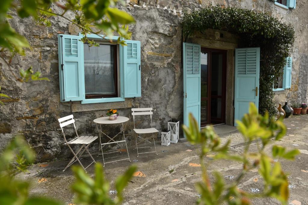 科佩尔Villa Carla - Istrian house的蓝色百叶窗建筑前的桌椅
