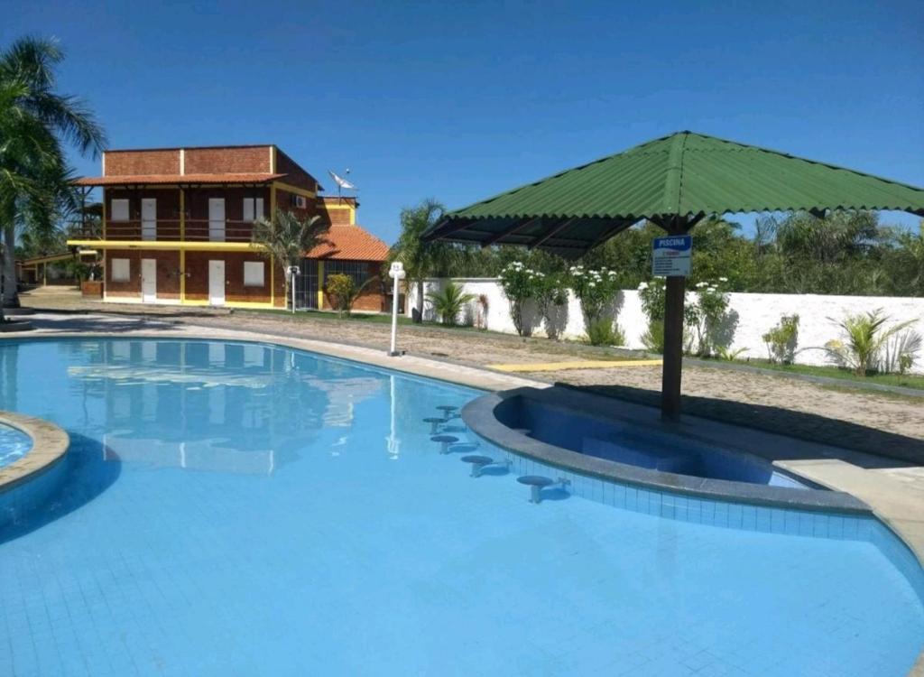巴雷里尼亚斯Chalé Descanso的房屋前带遮阳伞的大型游泳池