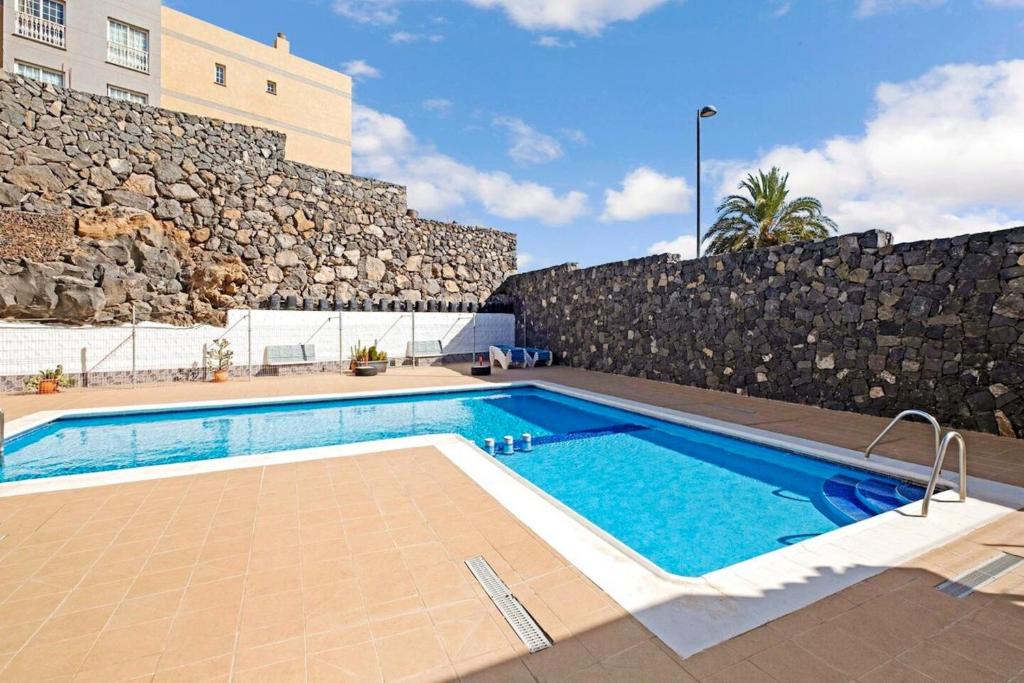 阿罗纳2 bedrooms appartement with shared pool furnished terrace and wifi at Costa del Silencio 1 km away from the beach的大楼前的游泳池