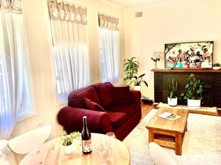 蒂默特Rose End Cozy Apartment的客厅配有红色的沙发和桌子