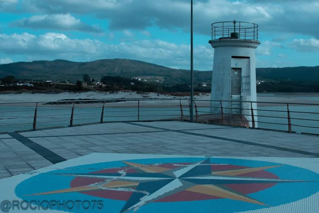 福斯Rapadoira Seaside Apartment的水体旁边的码头上的灯塔
