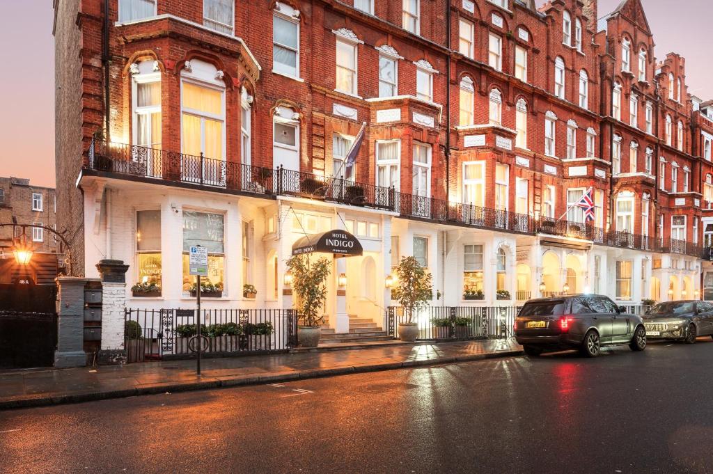 伦敦伦敦英迪格酒店 - 肯辛顿的停在大楼前的街道上的汽车