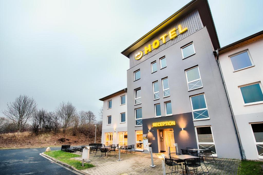 卡塞尔B&B Hotel Kassel-Süd的外面设有桌椅的酒店