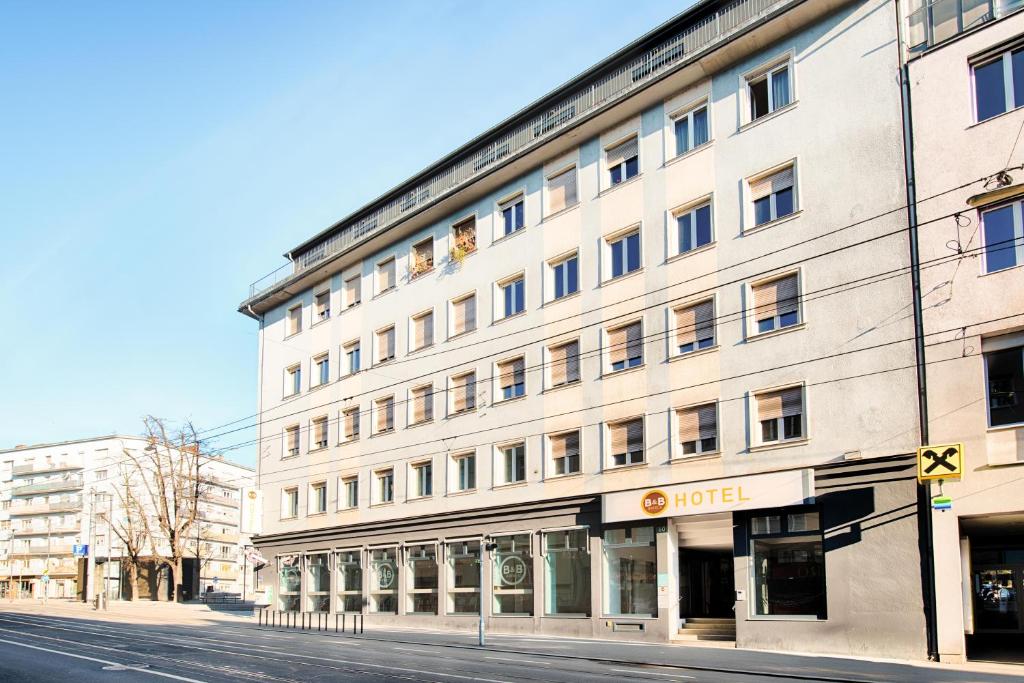 格拉茨B&B Hotel Graz-Hbf的一条城市街道上的白色大建筑
