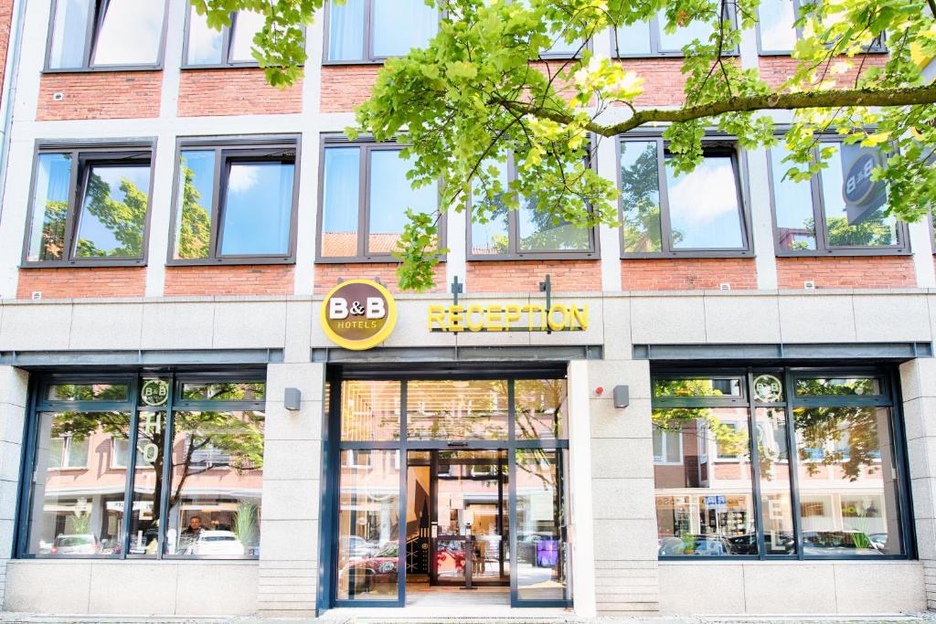 基尔B&B Hotel Kiel-Holstenbrücke的砖楼前方的商店,设有玻璃窗