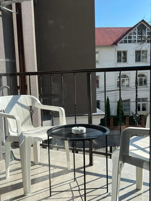 基希讷乌Downtown Accommodation的阳台配有两把椅子和一张桌子
