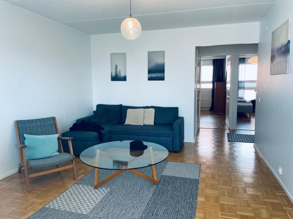 埃斯波Kalastajankuja Apartment的客厅配有蓝色的沙发和玻璃桌