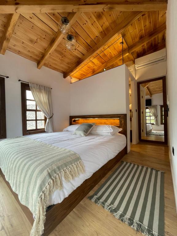 培拉特N'Gorice的一间卧室设有一张大床和木制天花板。