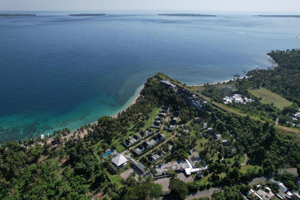 圣吉吉The Kayana Beach Lombok的水边山丘上房屋的空中景观