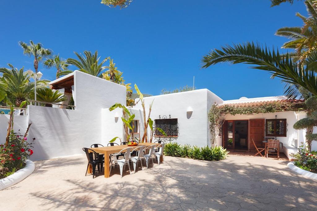 伊维萨镇CAN TEO - Holiday Villa in Ibiza的白色房子前面的一张桌子和椅子
