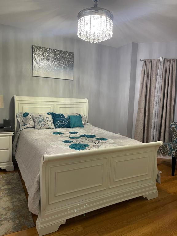 波士顿Brand New Luxury Rooms near downtown Boston的卧室内的白色床,配有吊灯