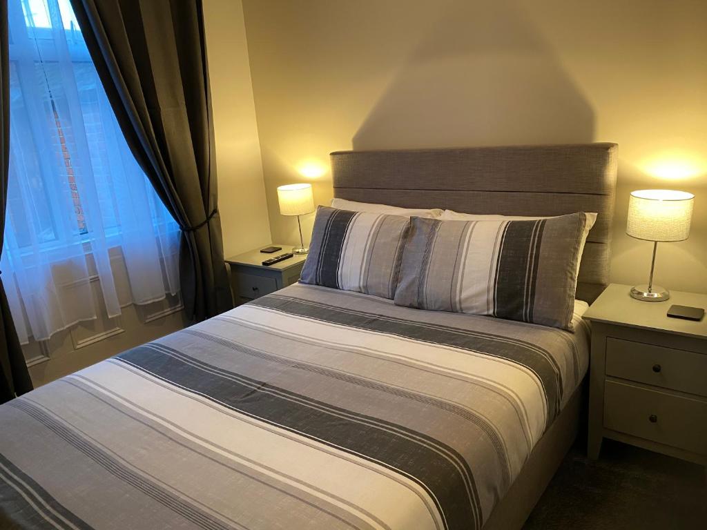 南希尔兹阿索尔宾馆的一间卧室配有一张带两盏灯的床和一扇窗户。