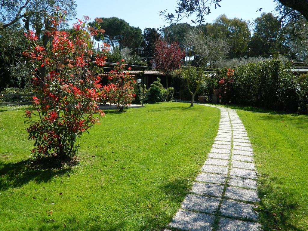 Castel di DecimaCountry Apartments的花园中一条种满红花的树的小路