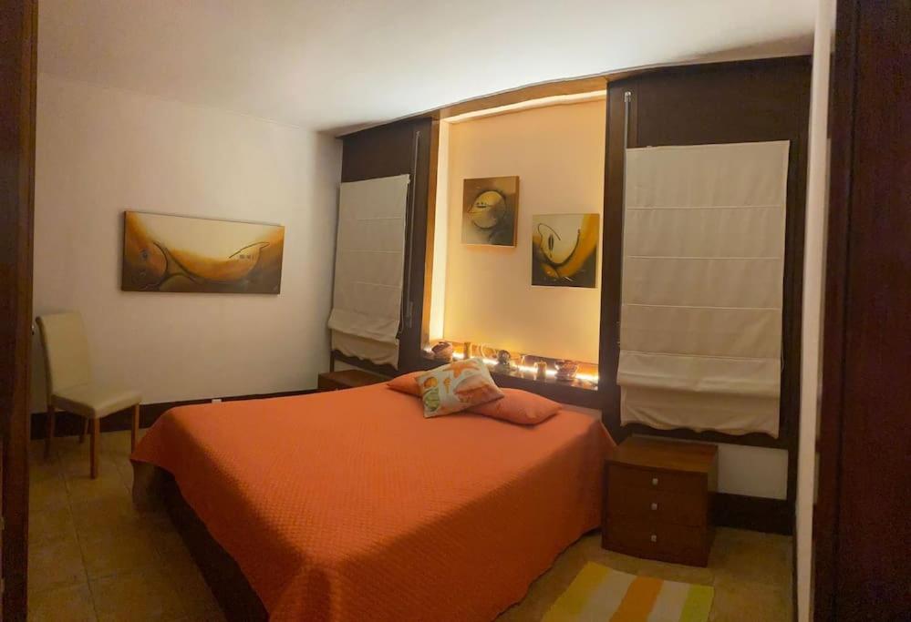 特罗亚Sunset Troia Beach的一间卧室配有橙色的床和窗户。