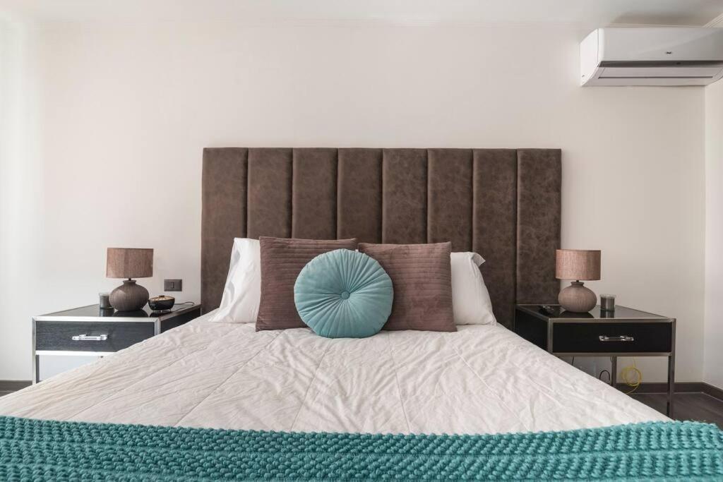 圣地亚哥Hermoso Apartamento en el Casco Histórico de Santiago的一间卧室配有一张大床,上面有蓝色的枕头