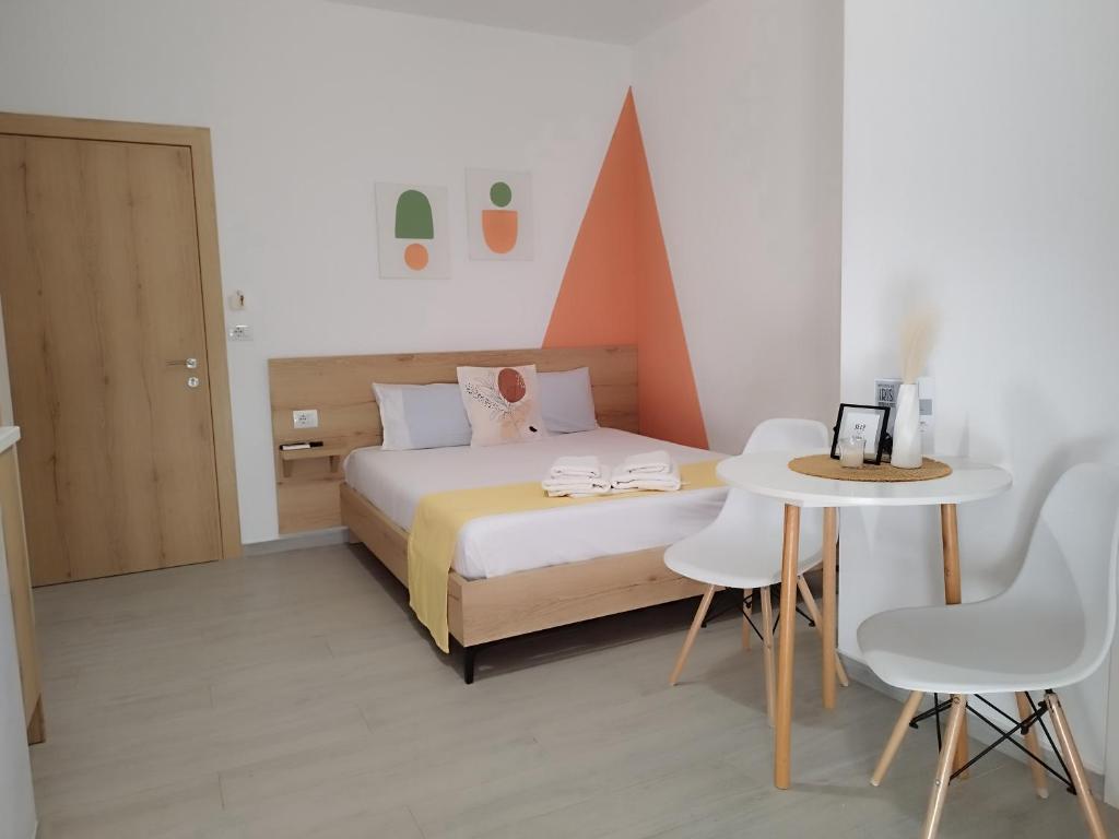 卡萨米尔Iris Apartments Ksamil的卧室配有一张床和一张桌子及椅子