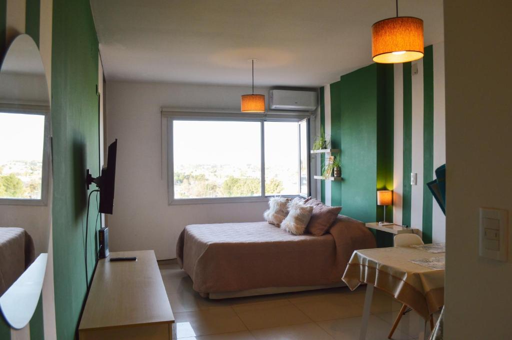 内乌肯Dolce Casa Departamentos的绿色的客房设有床和窗户。