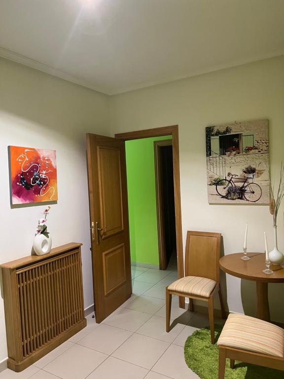 卢戈Motel Montecarlo的客厅配有桌子和绿门
