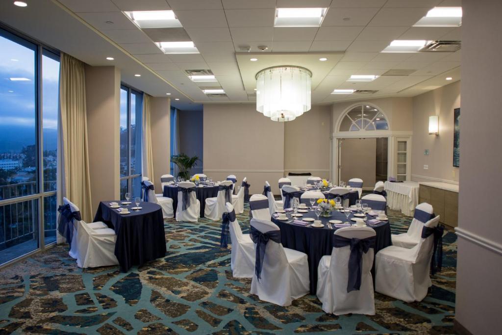 文图拉文图拉海滩皇冠假日酒店的宴会厅配有桌椅和吊灯。