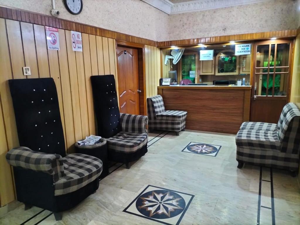 卡拉奇Jinnah Airport Hotel的一间设有三把椅子的等候室和一间酒吧