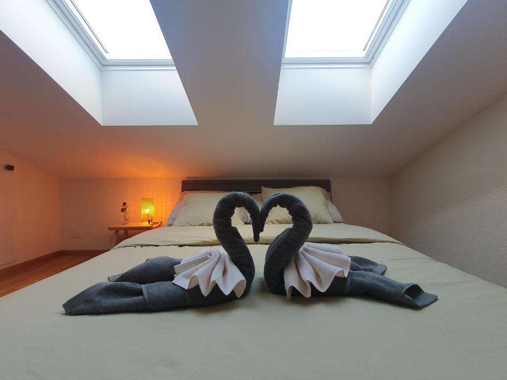沃韦Riviera Guest house - Private room in a shared appartment的阁楼上床边的两条毛巾天鹅
