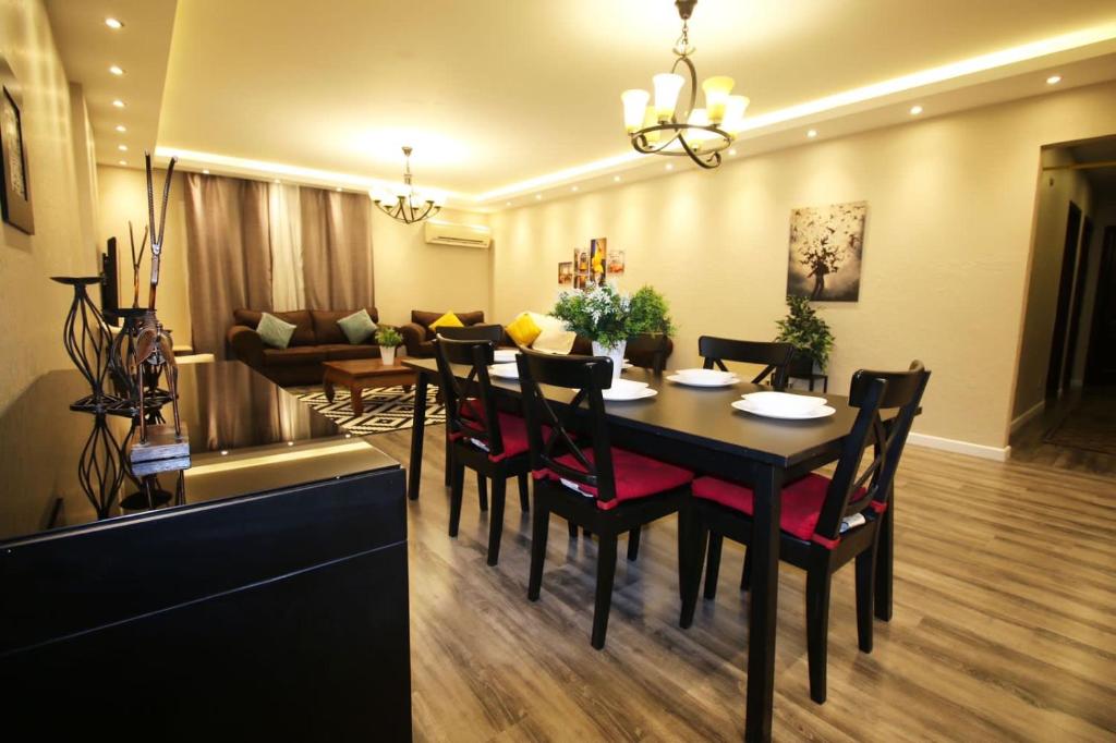开罗Sweet home in maadi的一间带桌椅和沙发的用餐室