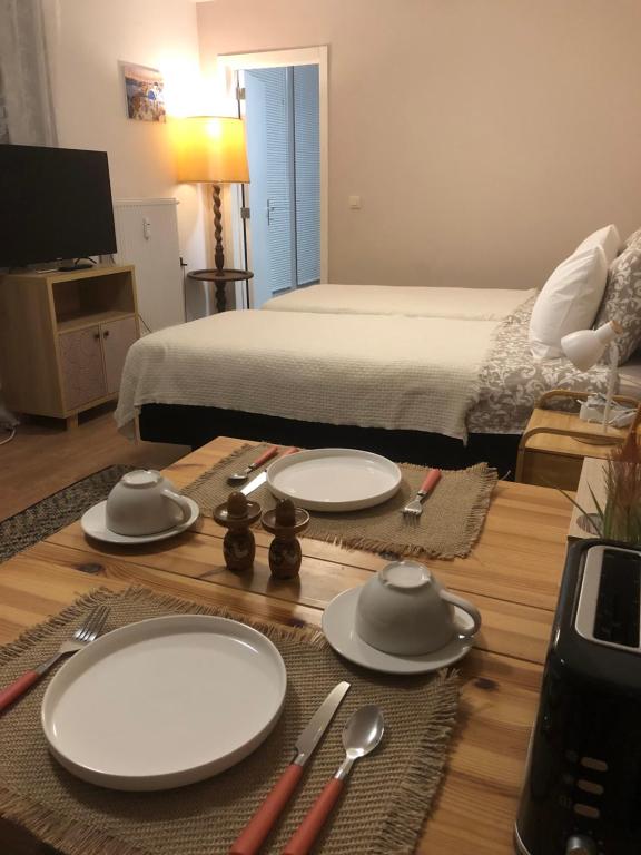 那慕尔Pina's Appartment的一张桌子,上面有盘子和餐具,还有一张床