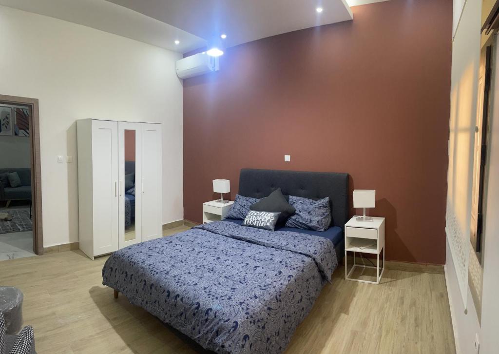 努瓦克肖特résidence zeineb的一间卧室配有蓝色的床和两张桌子