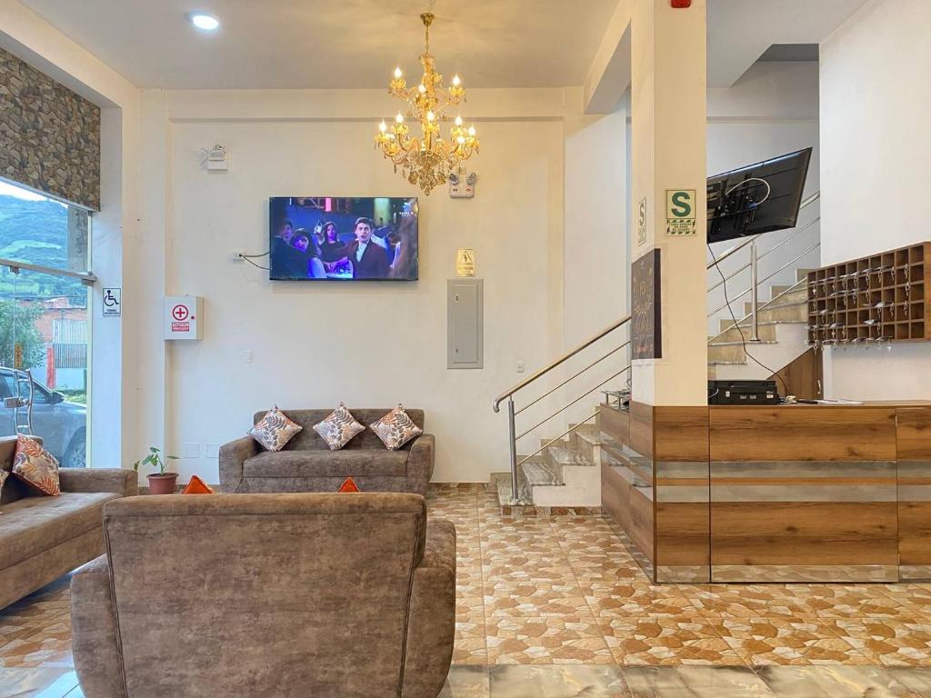 瓦拉斯Hotel Los Pajonales的客厅配有沙发和墙上的电视