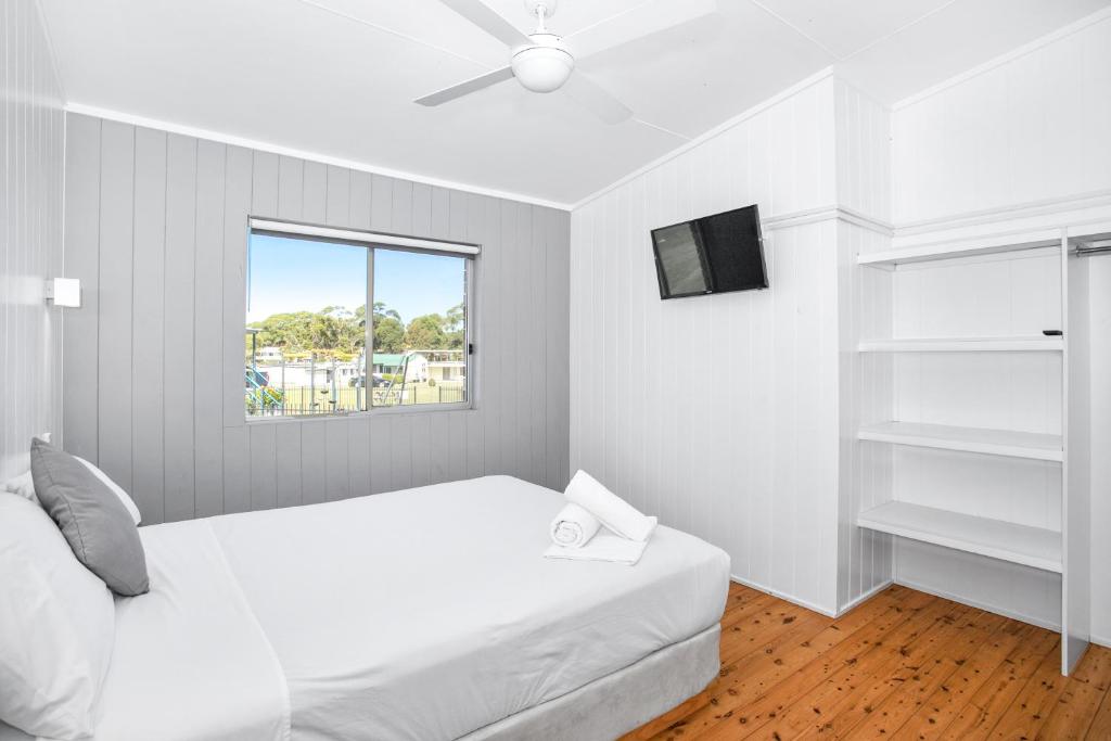 苏塞克斯入口湖滨小屋度假村的白色的卧室设有床和窗户