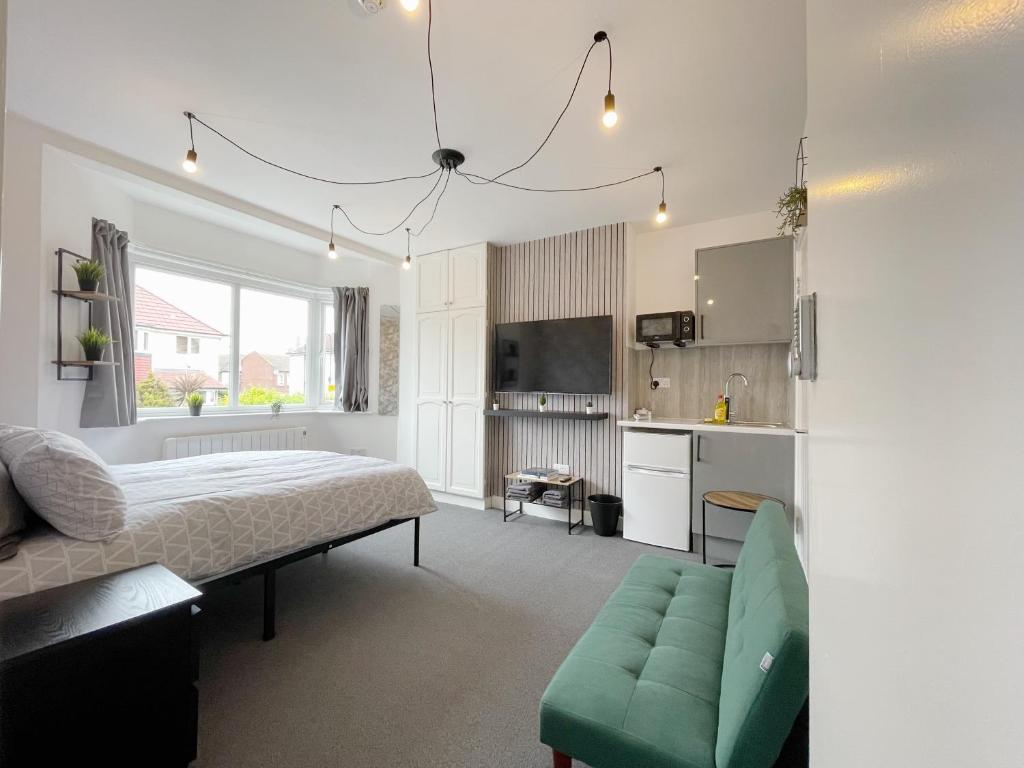 伦敦Cosy Bright Studio Apartment Close to Wembley Stadium的一间卧室配有一张床和一张沙发,还设有一间厨房