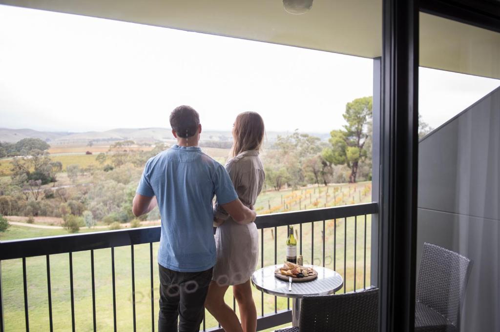 罗兰低地诺富特巴罗莎谷度假酒店的站在观景阳台的男女